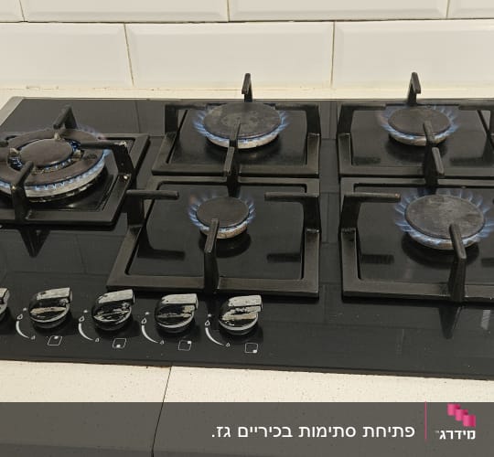 כיריים גז עם ארבעה מבערים דולקים